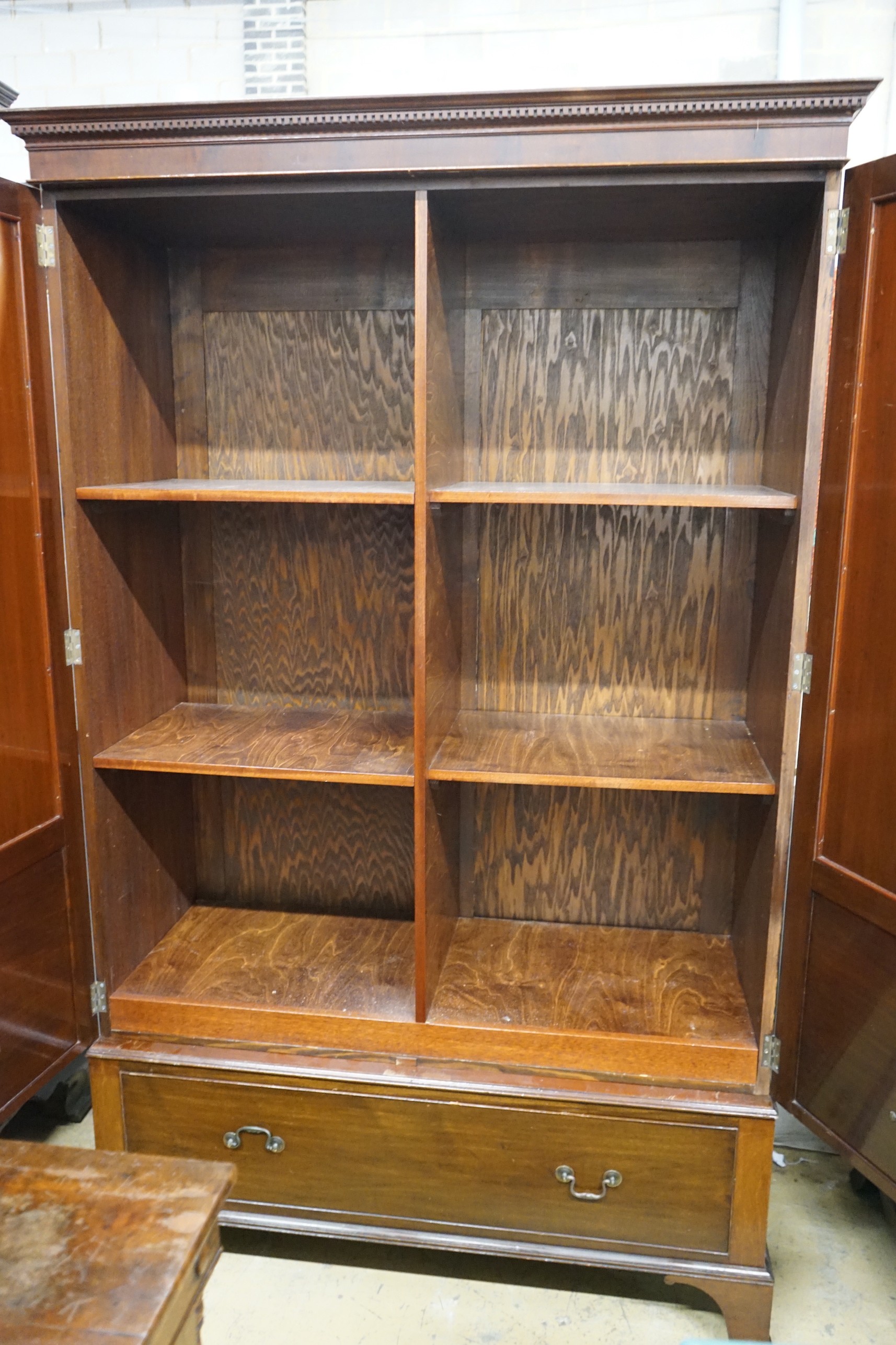 A 1920's mahogany press cupboard with part dummy drawer front over a single drawer, width 120cm, depth 50cm, height 196cm